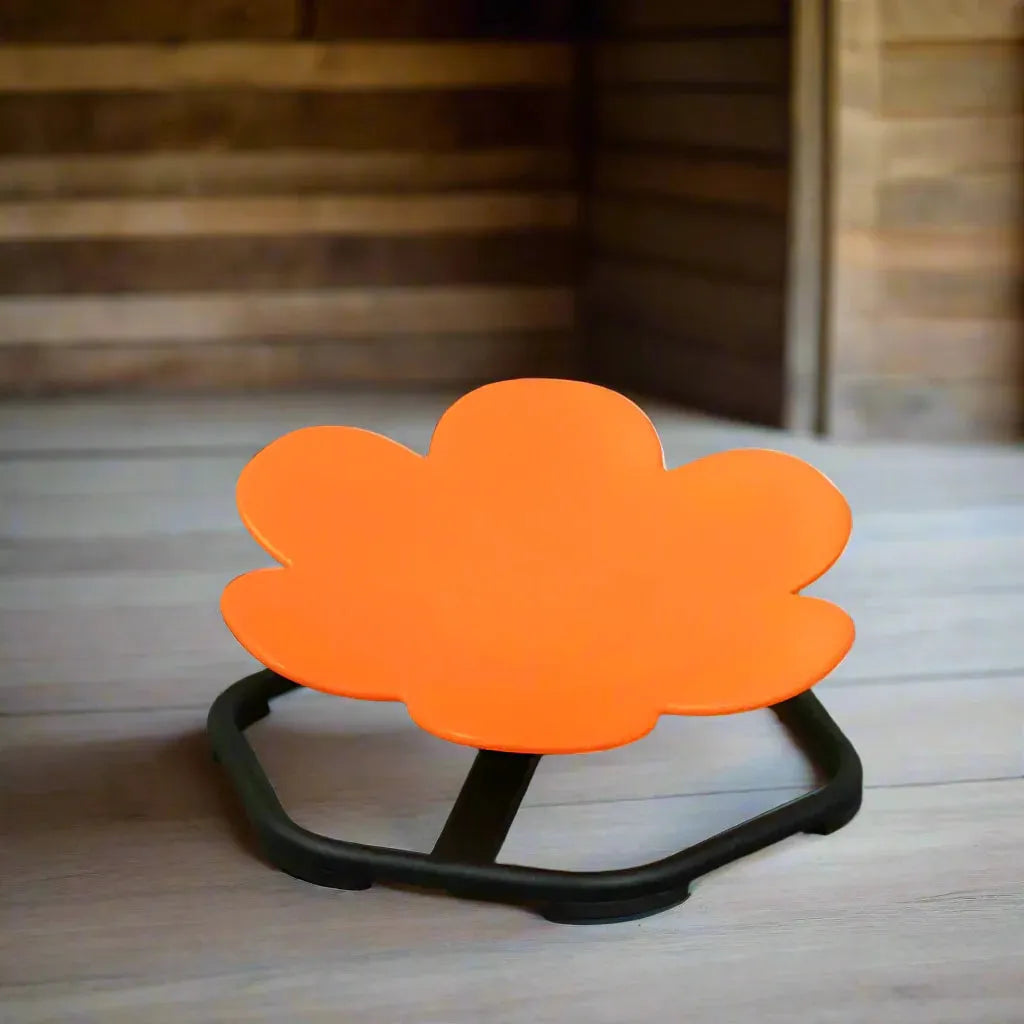 Bright orange sensory spinning chair with flower shape on wooden floor in playroom