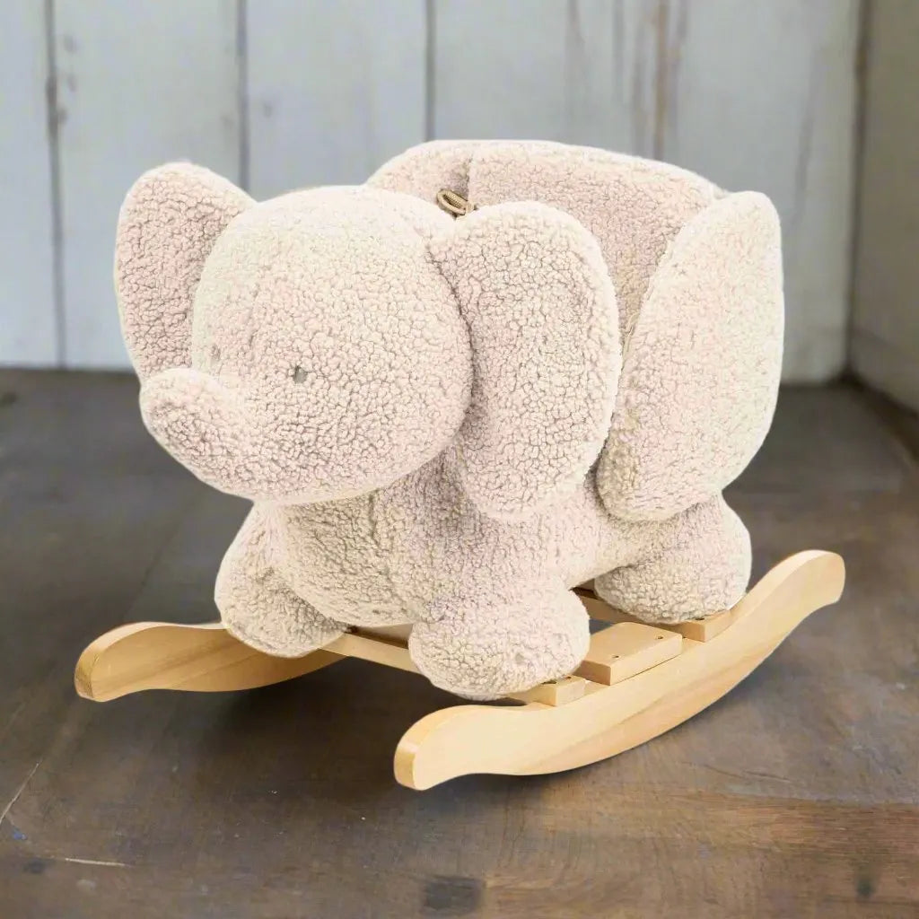 Plush elephant rocking horse with wooden base on brown floor, kids room décor