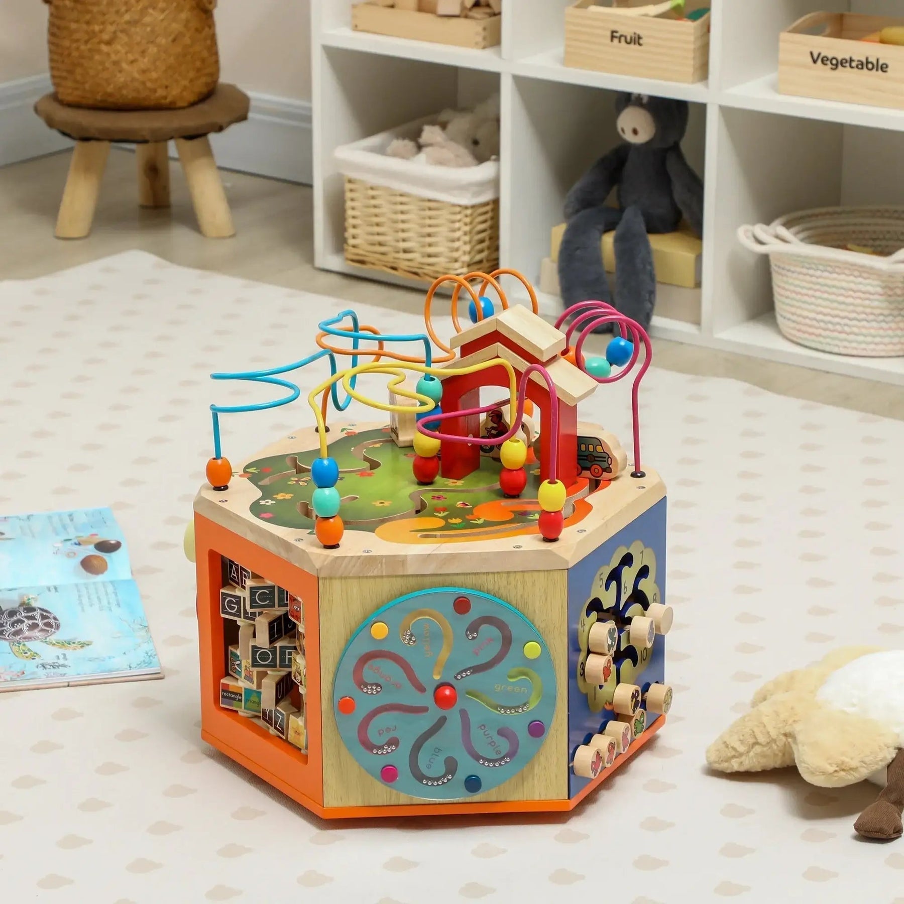 Wooden activity cube toy with colorful bead maze in a modern playroom setting