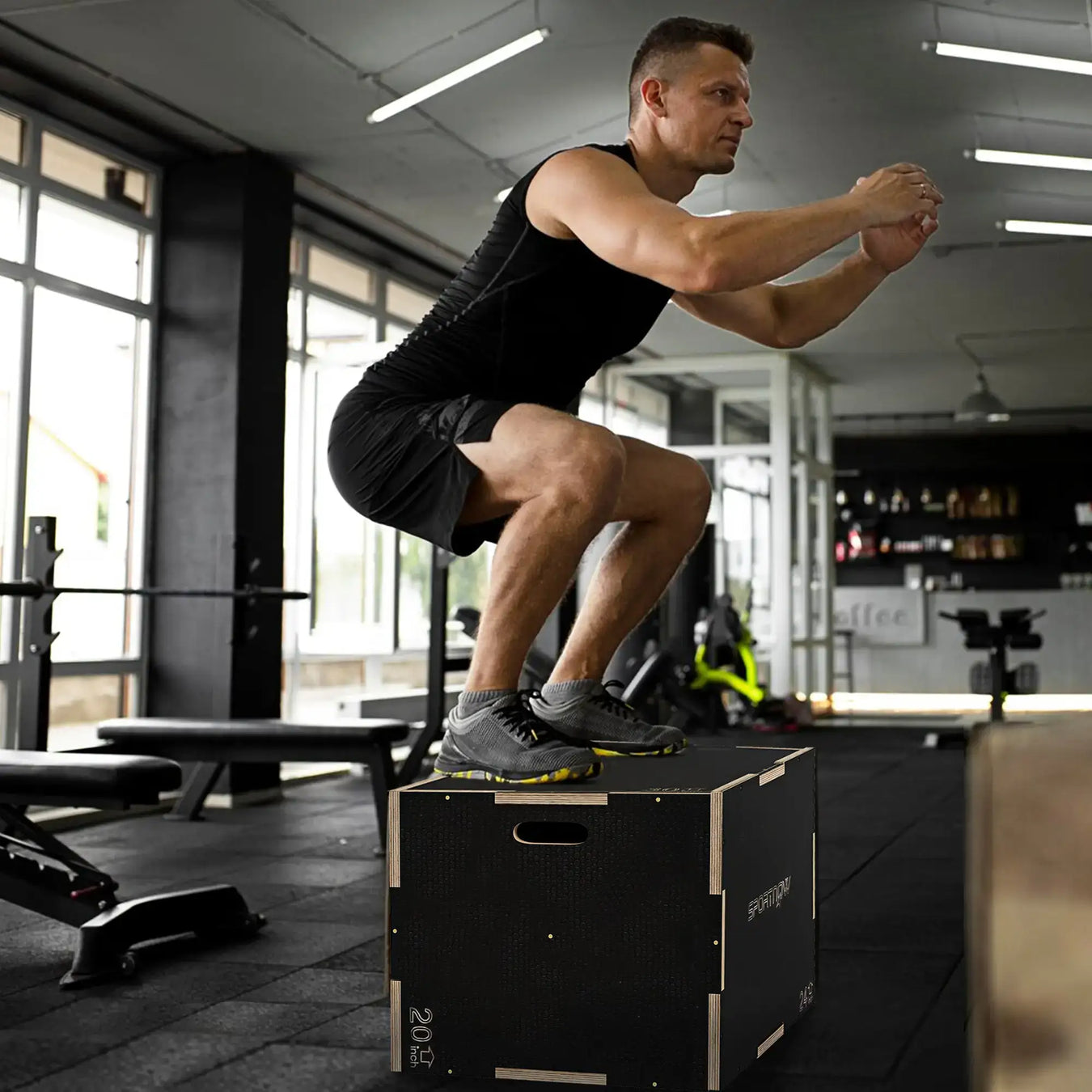 Man in gym using portable plyometric fitness box for box jump workout