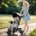 Woman pushing a child in a stroller outdoors on a sunny day