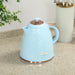 Light blue electric kettle on a kitchen counter with a plant and container in the background.