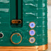 Close-up of a green toaster with control buttons on a wooden surface