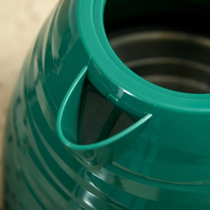 Close-up of a green plastic container with a black mesh filter inside.