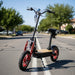 1000W electric scooter with seat, off-road tires, and red accents on a suburban street