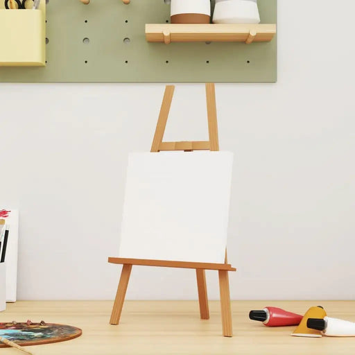 Blank stretched canvas on wooden easel with art supplies in a bright artist studio