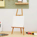Blank stretched canvas on wooden easel with art supplies in a bright artist studio