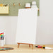 Blank stretched canvas on mini easel with painting supplies in art studio workspace