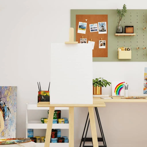 Blank stretched canvas on easel in bright art studio with painting supplies