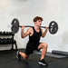 Man performing barbell lunges in a gym setting