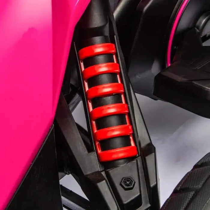 Close-up of red suspension spring on pink 12V kids electric go-kart ride-on vehicle