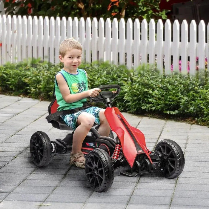 Child riding red 12V kids electric go-kart outdoors near white fence on paved path