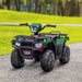 Green and black kids electric quad bike with LED headlights on a paved path outdoors