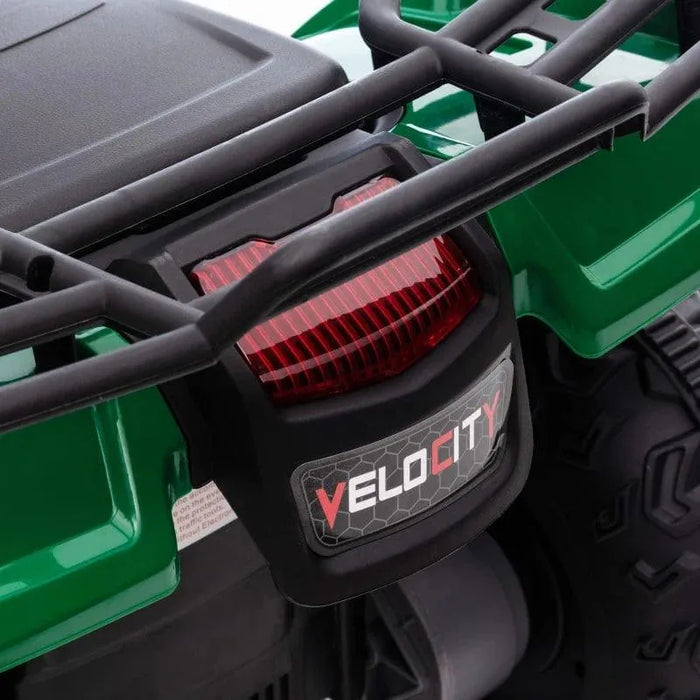 Close-up of green kids electric quad bike rear rack, red taillight, and Velocity logo