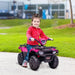Smiling child riding pink and black 12V kids electric quad bike outdoors