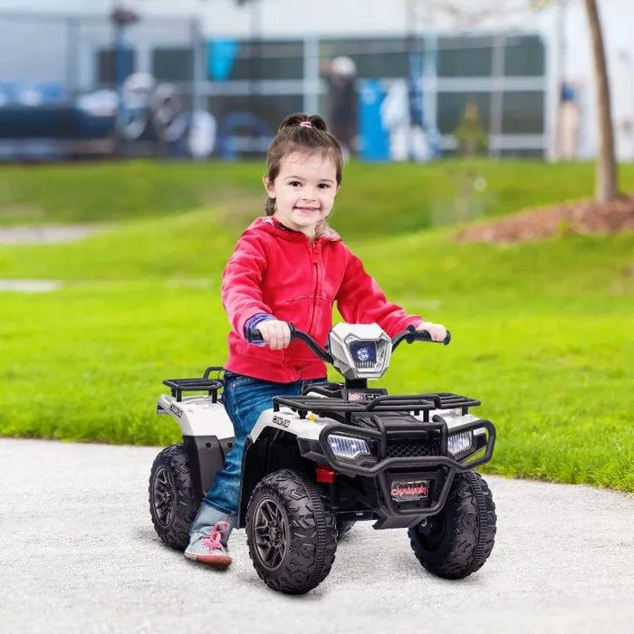 Child riding white and black 12V electric quad bike with LED headlights outdoors