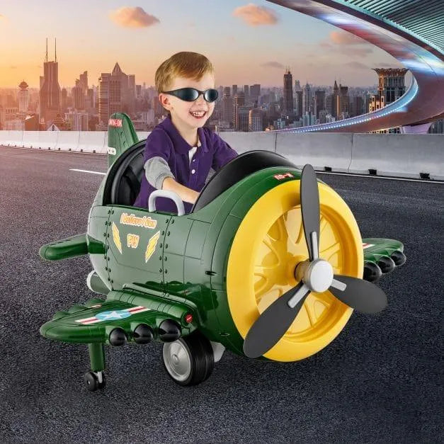 Smiling boy rides 12V kids green electric airplane toy on city bridge at sunset