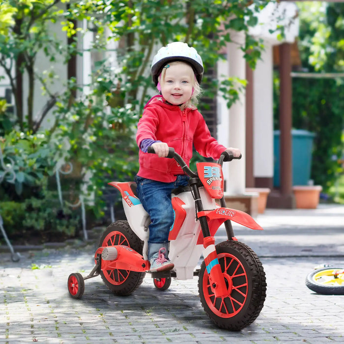 Child riding red 12V kids electric ride-on motorbike with training wheels outdoors