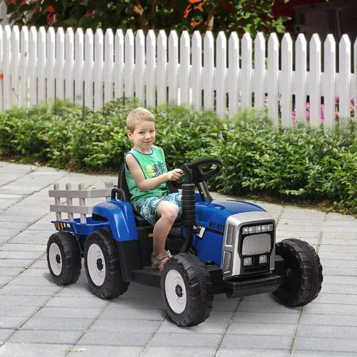 Child riding blue 12V electric toy tractor with trailer outdoors on paved path