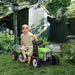 Child on green 12V kids electric ride-on tractor with detachable trailer in garden