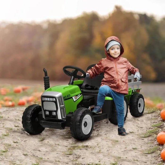 Child in autumn pumpkin patch with green 12V kids electric ride-on tractor and trailer