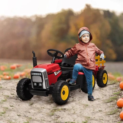 Child on red 12V electric ride-on tractor with detachable trailer in a pumpkin field