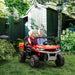 Two kids riding red 12V electric UTV toy car with music system in a backyard garden