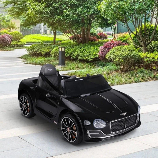12V kids black Bentley GT electric ride-on car with LED lights parked on paved path outdoors