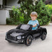 Child driving black 12V Bentley GT kids electric ride-on car outdoors with LED lights