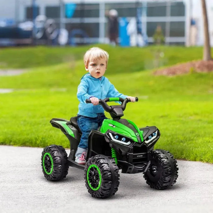 Child riding green 12V kids ride-on quad ATV bike with LED headlights outdoors