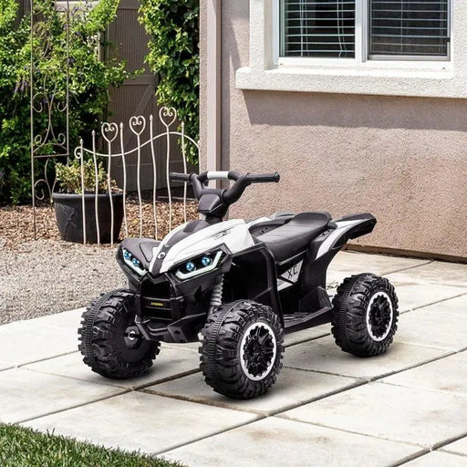 White 12V kids ride on quad ATV bike with LED headlights parked on patio outside house