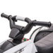 Close-up of handlebars on white 12V kids ride-on quad ATV bike with control buttons