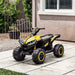 Yellow 12V kids ride on quad ATV bike with LED headlights parked on outdoor patio