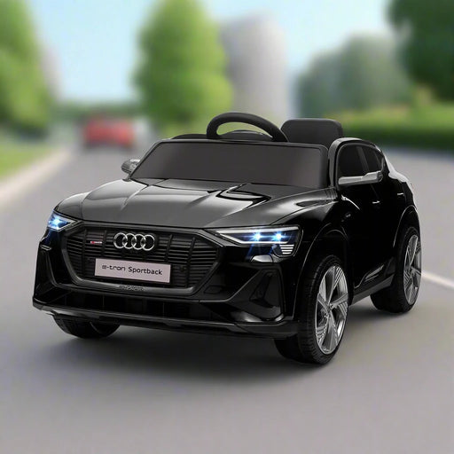 Black 12V Audi e-tron kids electric ride-on car with LED headlights on road