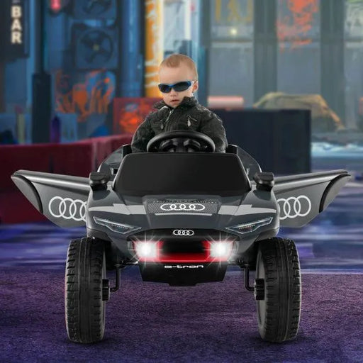 Child in sunglasses drives 12V Audi e-tron kids electric ride-on car with lights and open doors