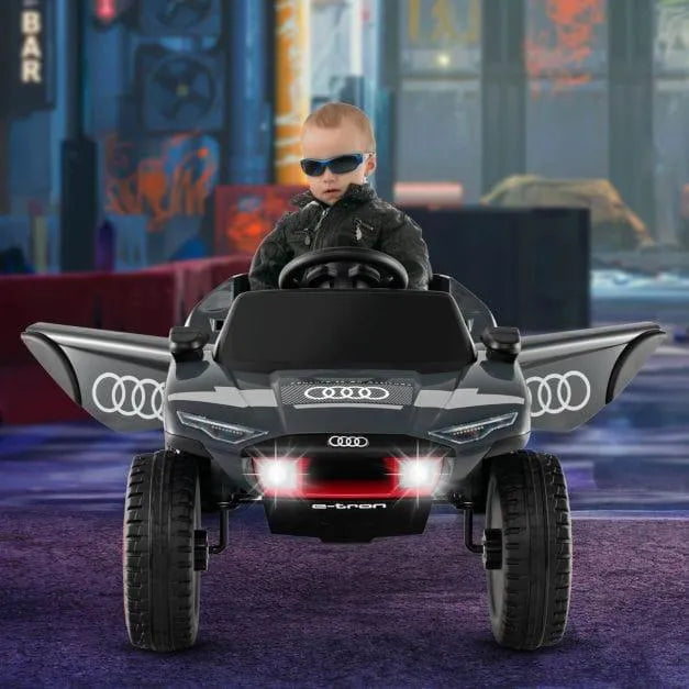 Child in sunglasses drives 12V Audi e-tron kids electric ride-on car with lights and open doors
