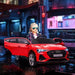 Child in red Audi e-tron Sportback kids ride-on car with LED lights and open doors