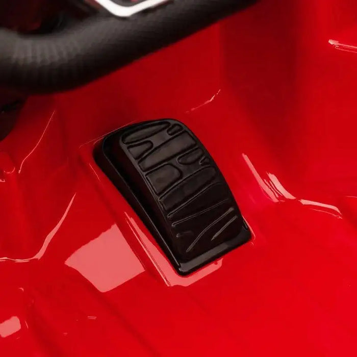 Close-up of black pedal in red 12V Audi RS e-tron GT kids electric ride-on car