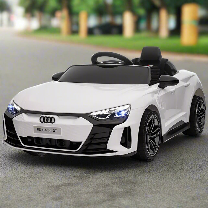 White Audi RS e-tron GT 12V kids ride-on car with LED headlights on pavement