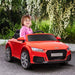 Child driving red 12V Audi TT RS kids electric ride-on car outdoors with flowers