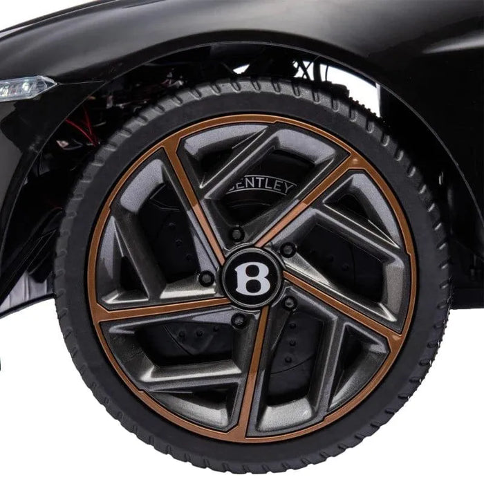 Close-up of black Bentley Bacalar kids ride-on car wheel with metallic bronze trim