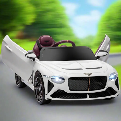 White 12V Bentley Bacalar kids electric ride-on car with open butterfly doors on road