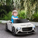 Child drives 12V white Bentley Bacalar kids electric ride-on car with LED lights outdoors