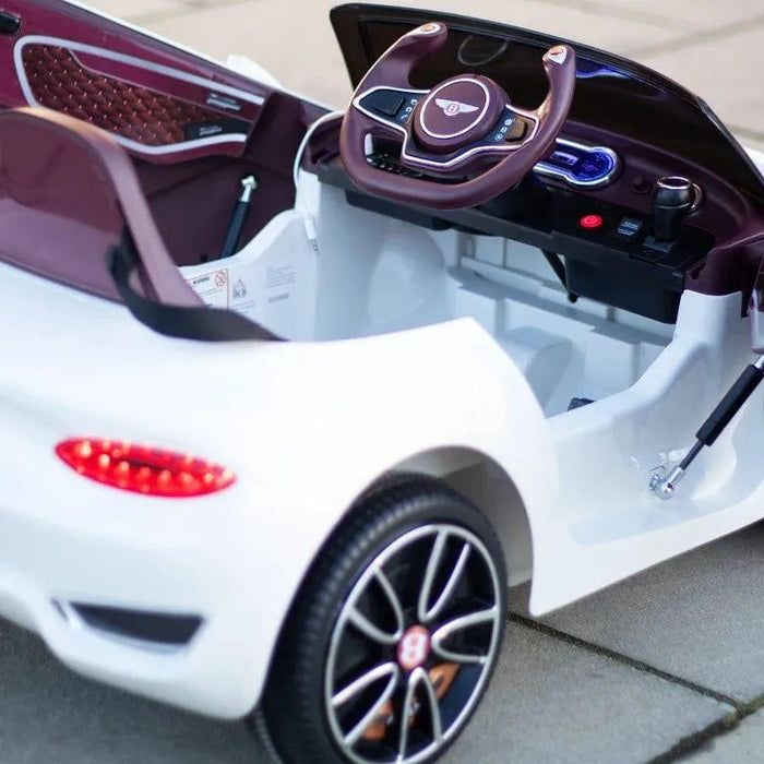 White 12V Bentley kids electric ride-on car with detailed dashboard and black wheels