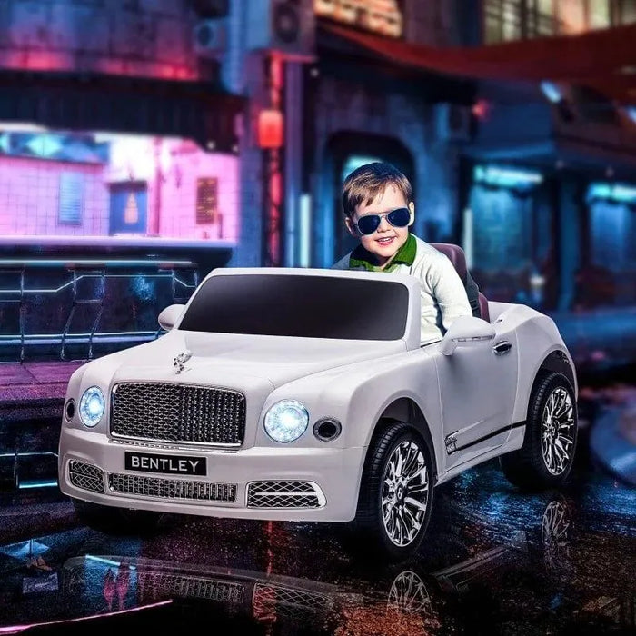 Child in white Bentley Mulsanne kids ride-on car with lights, city street background at night