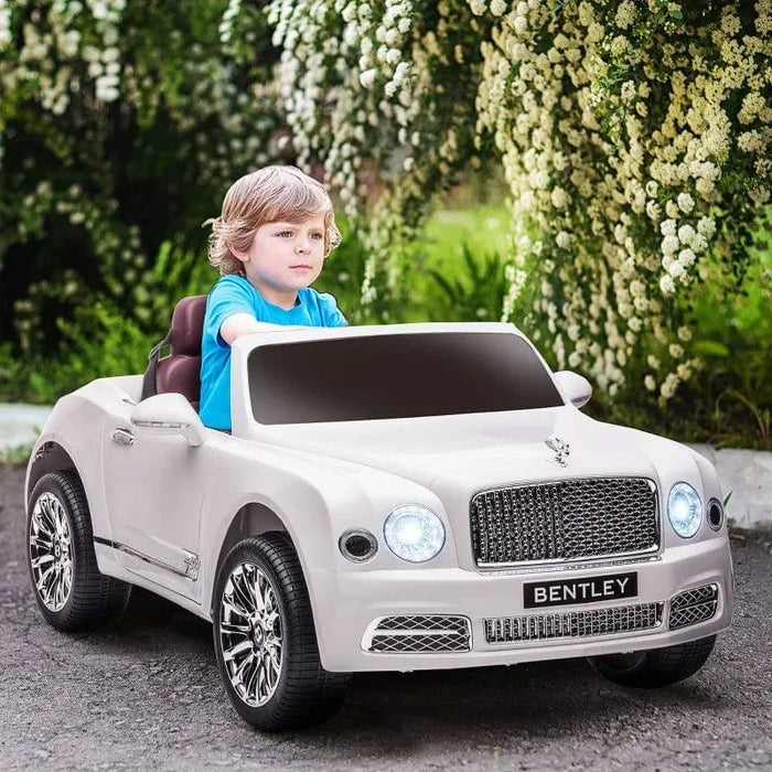 Child driving white Bentley Mulsanne kids ride on car with LED headlights outdoors