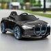 12V black BMW i4 kids electric ride-on car with blue accents on a road