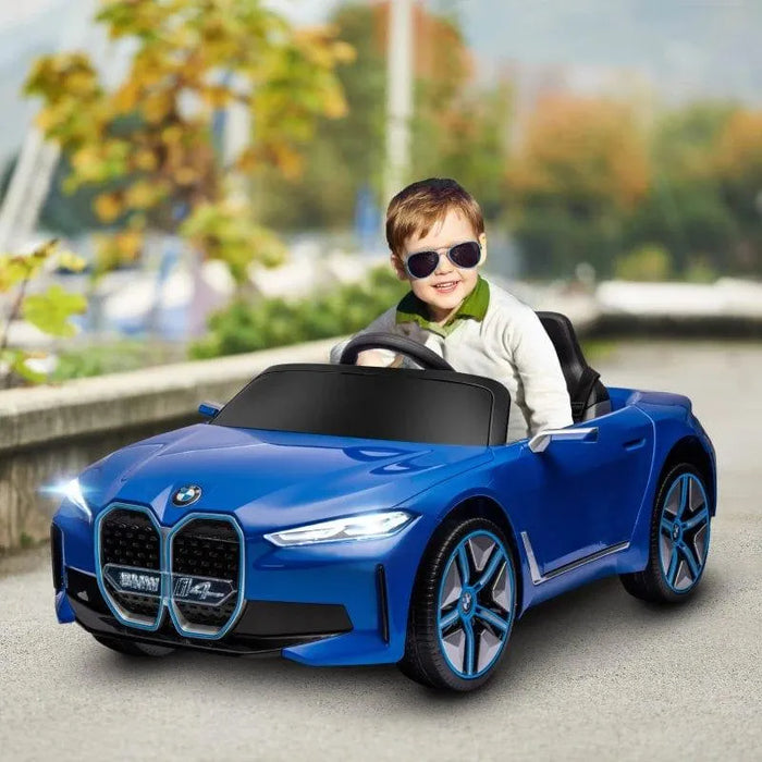 Child driving blue 12V BMW i4 kids ride on car with lights outdoors