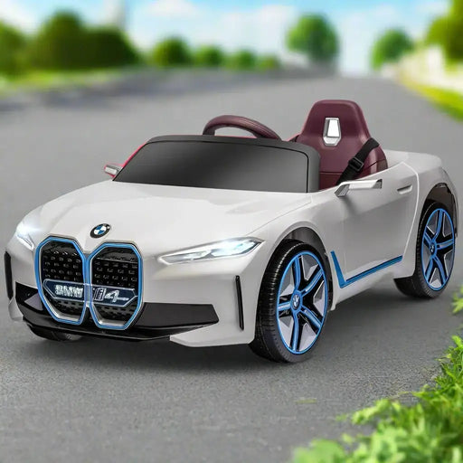 White 12V licensed BMW i4 kids ride on car with blue trim parked on road