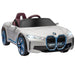 White 12V BMW i4 kids ride-on car with blue accents, headlights on, and realistic design